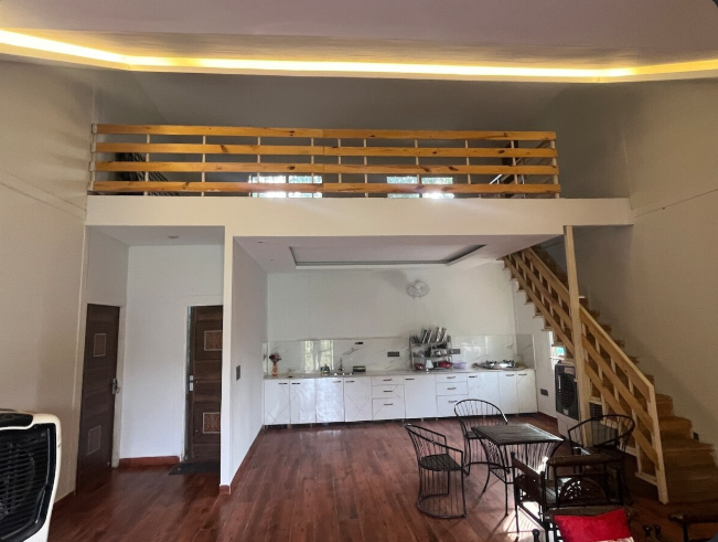Expostay Farm living area with kitchenette dining space and wooden staircase