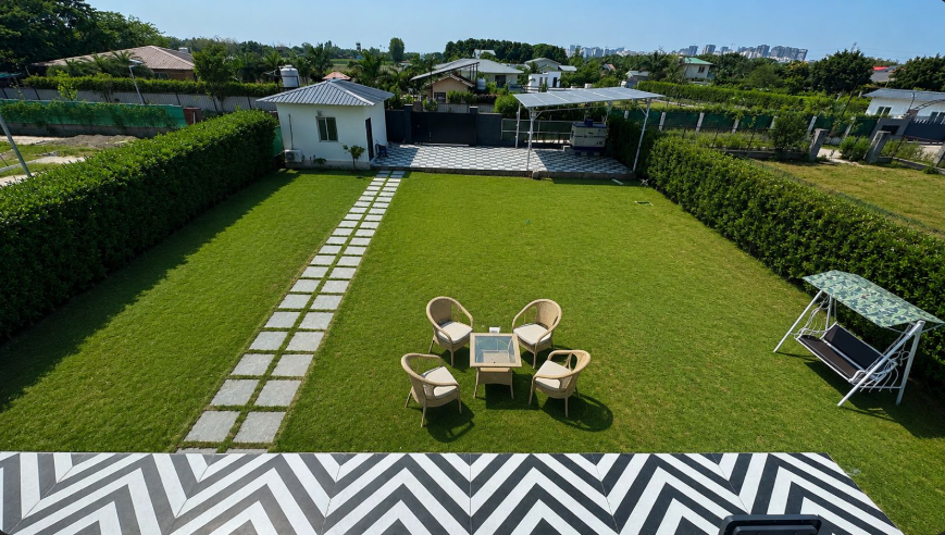 Aerial view of the green lawn and outdoor seating at Shiv Kashi Farmhouse Sector 135 Noida